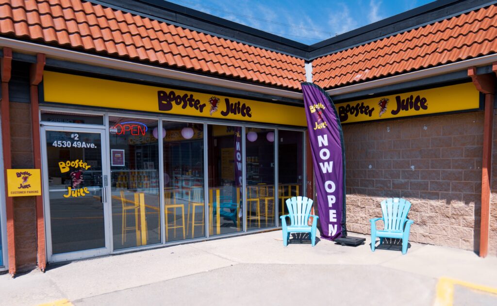  A vibrant and inviting storefront of a Booster Juice location, featuring the brand's logo and signage, enticing passersby with its refreshing and healthy beverage options.