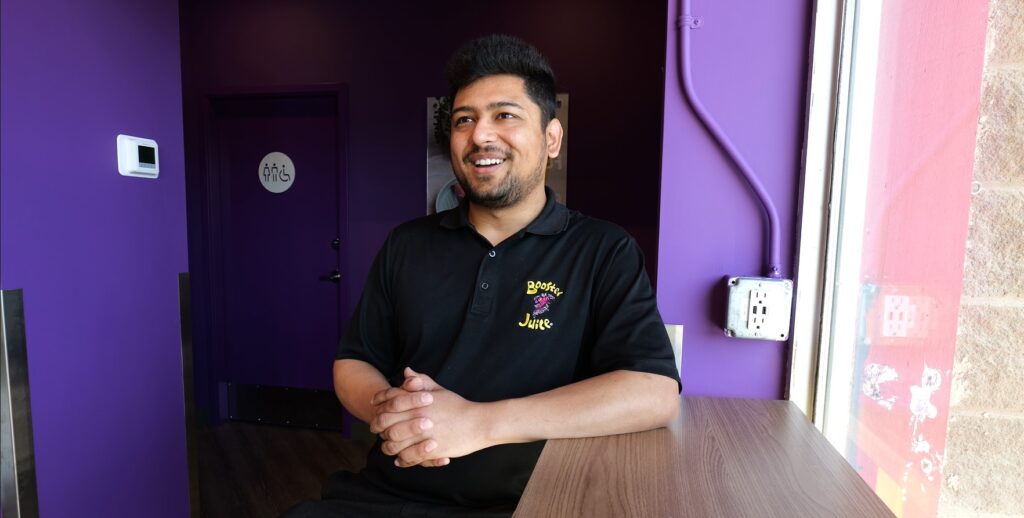  Dhrumil, owner of Booster Juice in Olds, Alberta, showcasing a selection of delicious and healthy smoothies.