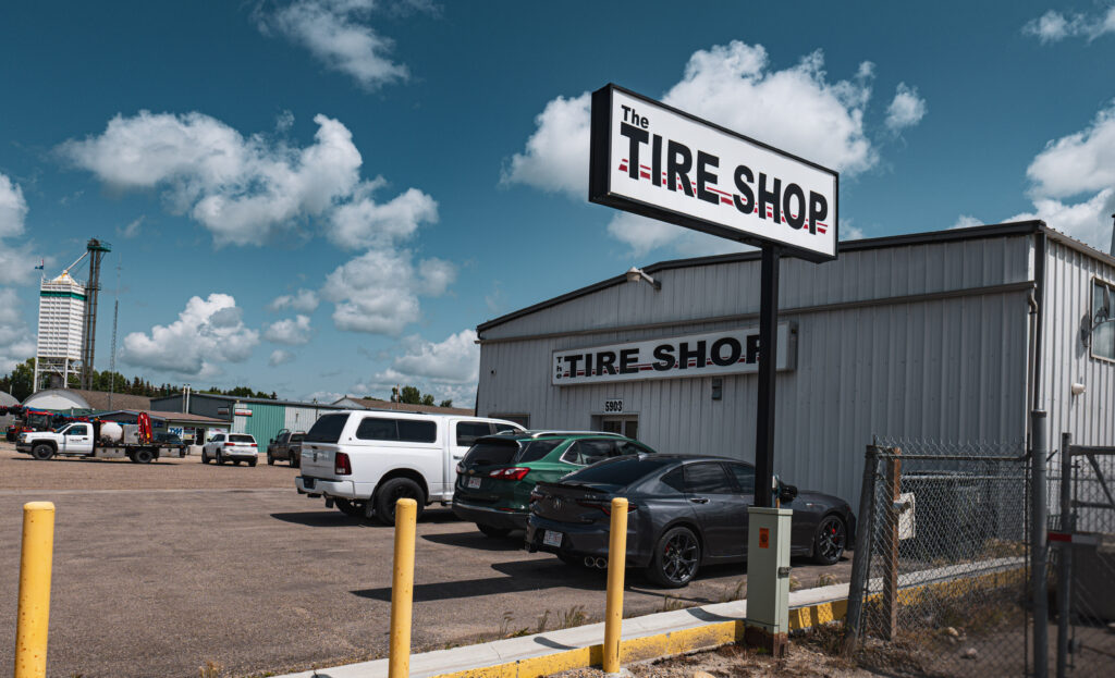 Exterior view of a busy tire shop, with various types of tires displayed prominently in the front.