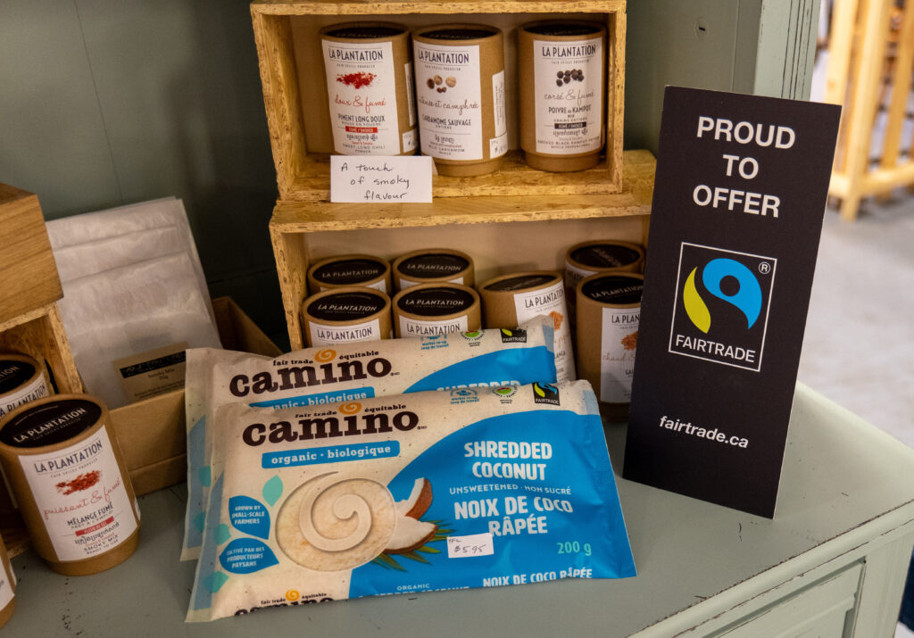 Image showcasing a variety of fair trade products available in Olds, Alberta, including coffee, chocolate, tea, and sugar, all bearing fair trade certification labels. The products are arranged neatly, highlighting the town's dedication to ethical and sustainable trade practices.