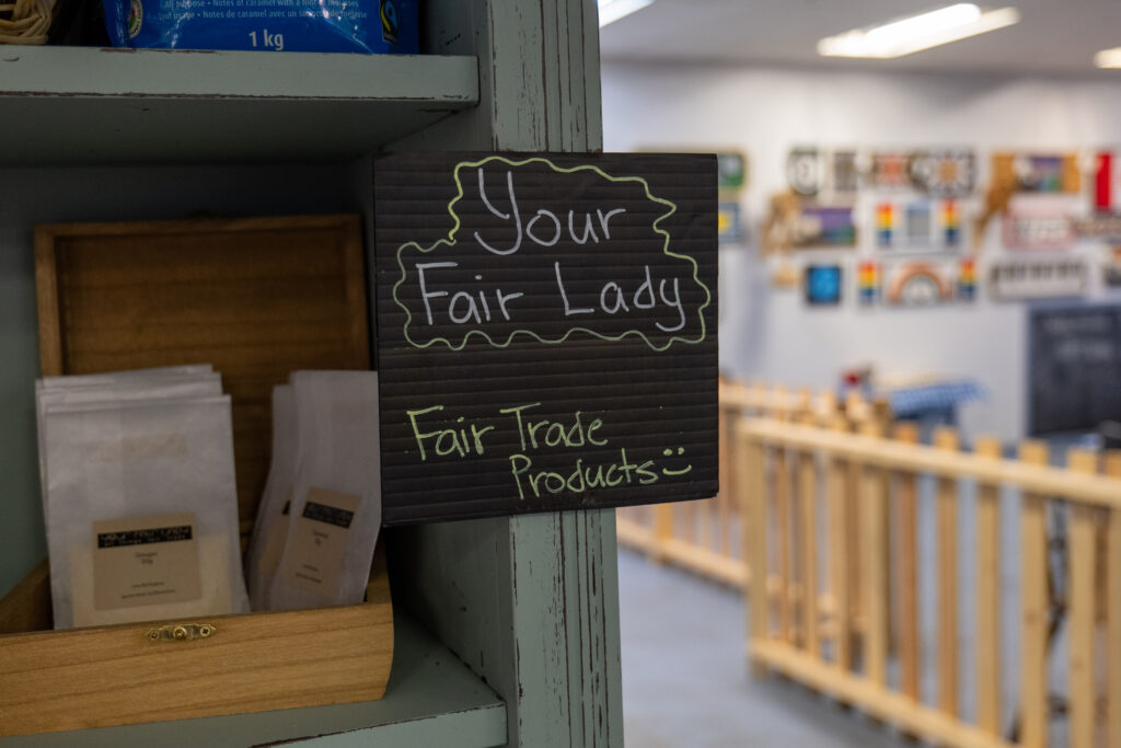 Image displaying a sign with the text 'Your Fair Lady' prominently featured, symbolizing the commitment to fair trade and ethical business practices in Olds, Alberta. The sign represents a local business embracing the fair trade movement.