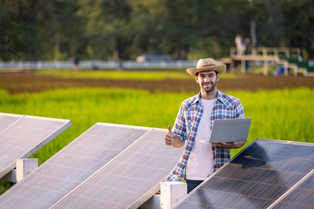 Solar panels and a farmer who is using Mountain View Power and enjoys the solar energy that powers his farm and electronics.
